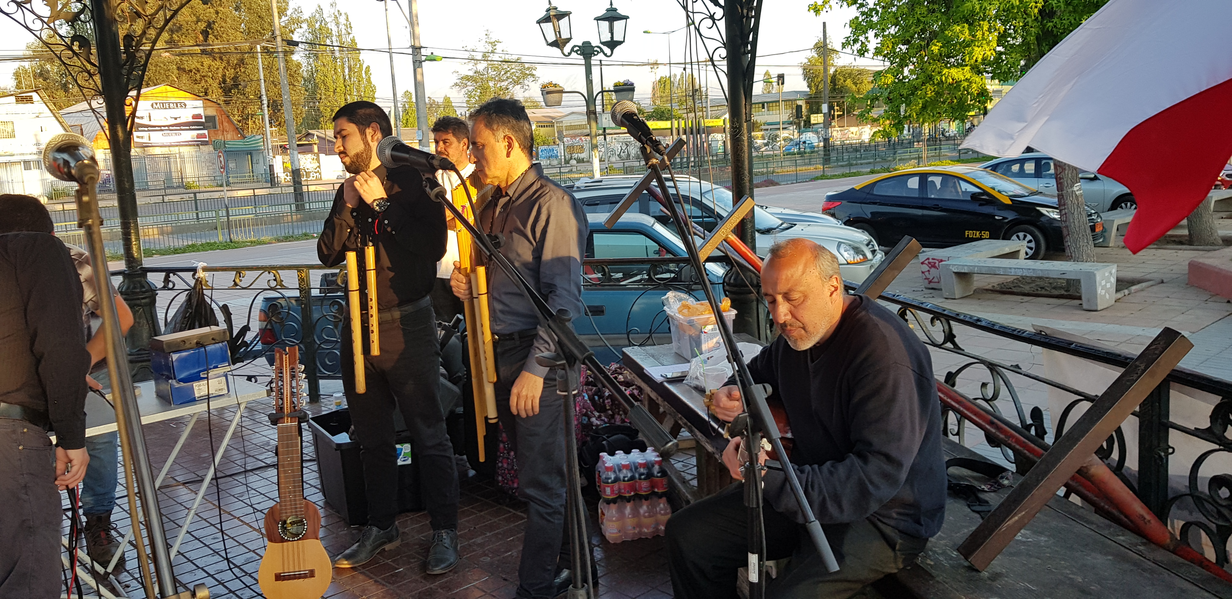 Grupo Origen tocando al aire libre junto a la bandera de Chile